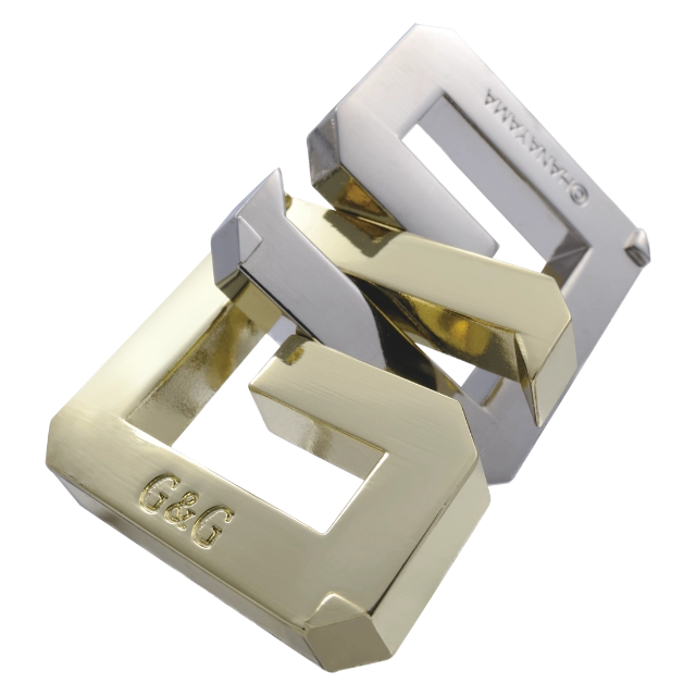 Een metalen, ingewikkelde 3D-puzzel met een G ontwerp, bestaande uit meerdere verweven G delen die samen een uitdagend geheel vormen.